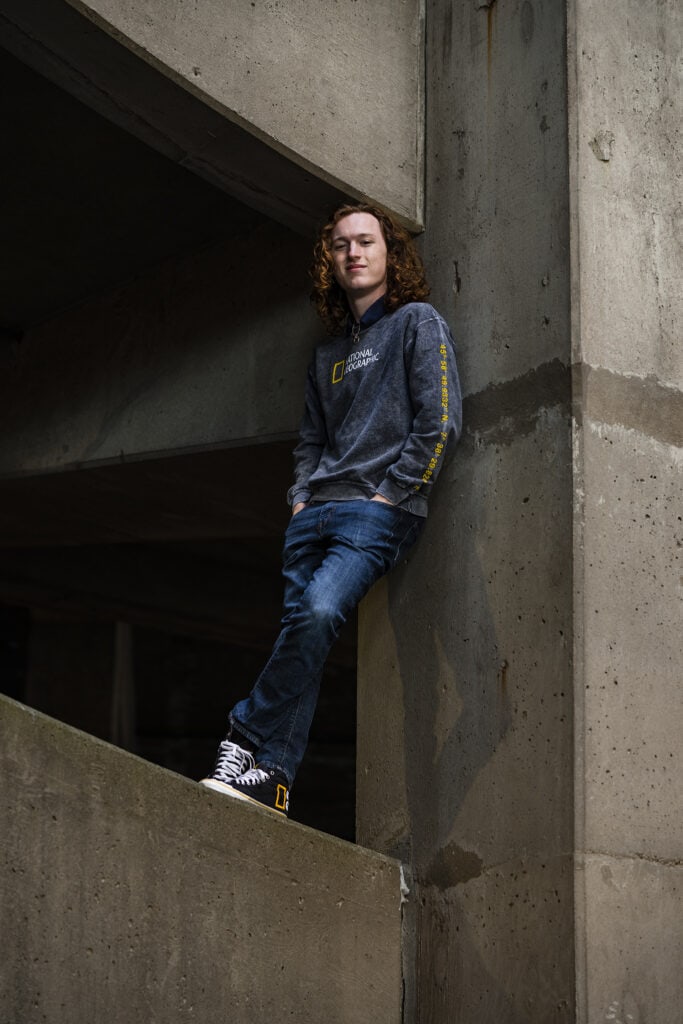 Senior guy stands in a parking garage in downtown Dayton during his senior pictures.